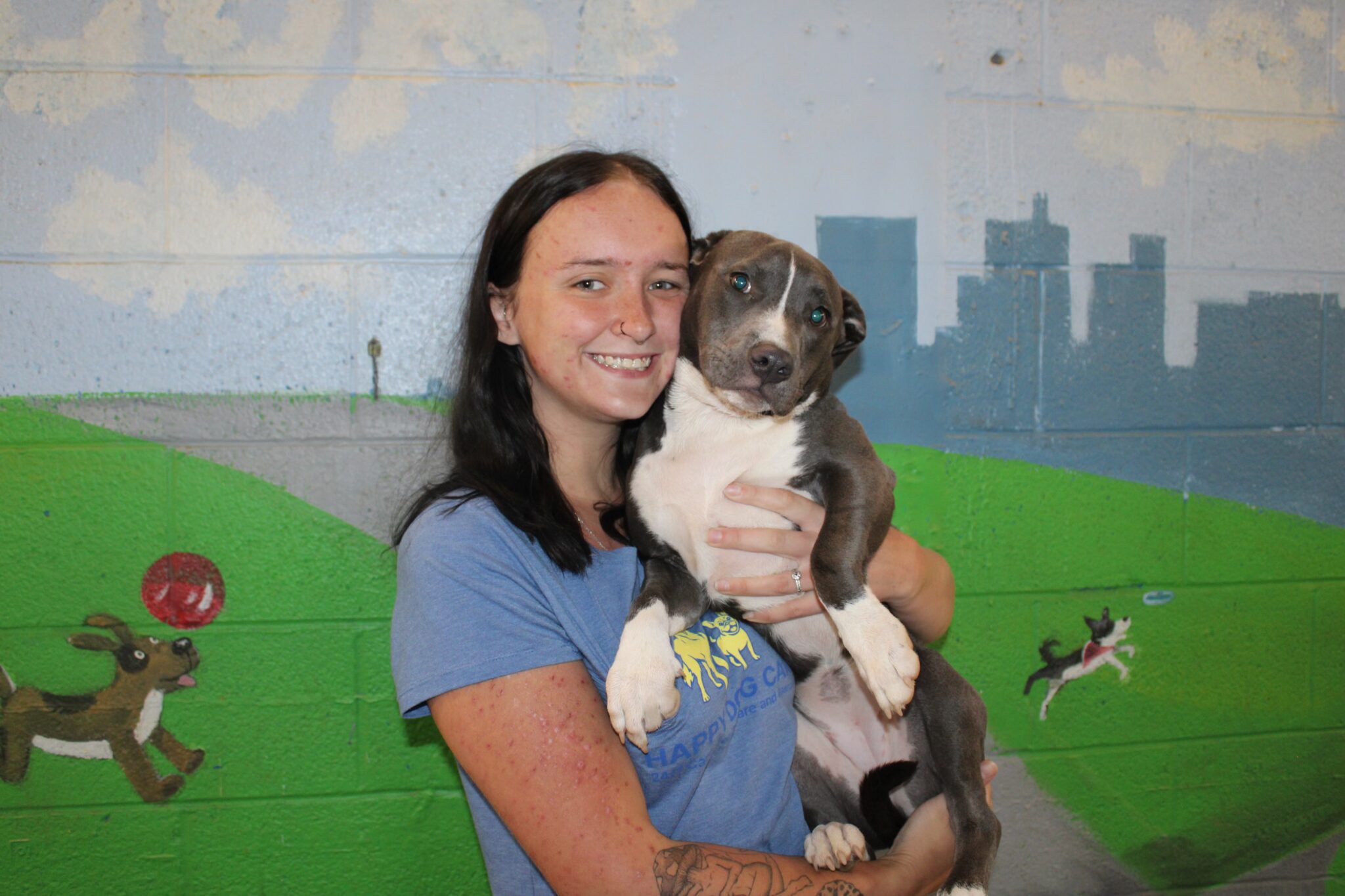 Staff member holding puppy at Happy Dog Care for Dog Daycare near Columbia, MD
